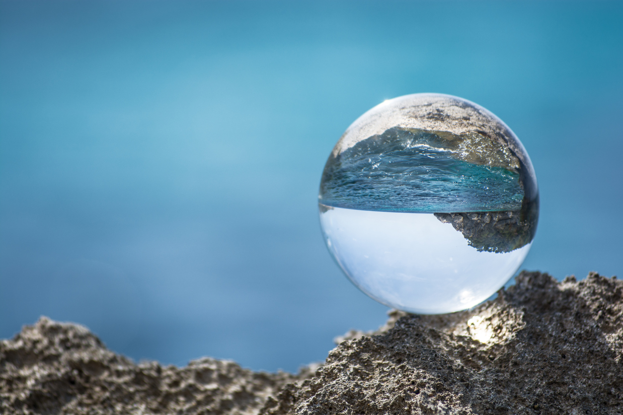 Glaskugel liegt auf einen Felsen vor dem Meer als Metapher für aufsichtsrechtliche Entwicklungen für das Zinsänderungsrisiko im Anlagebuch (IRRBB)