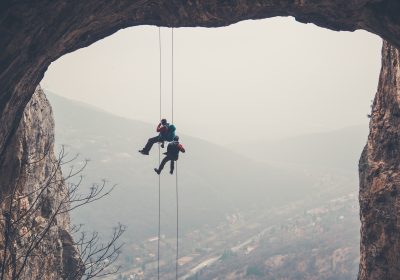 2 Kletterer die sich an der Wand herunterlassen als Metapher für neue Leitplanken für die Risikotragfähigkeit