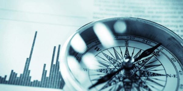 Close-up eines Kompasses vor Aktienmarkt-Daten als Metapher für Private Banking Deutschland 2018