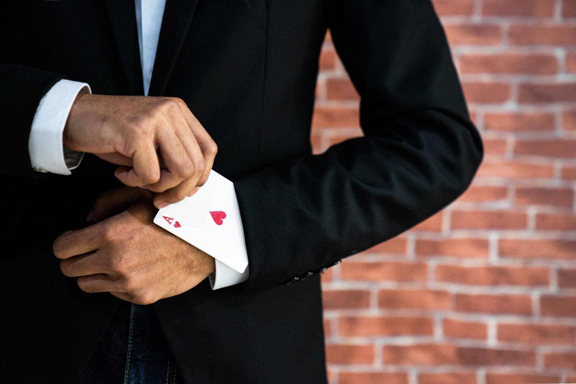 Abstraktes Bild eines Geschäftsmann der ein Pik Ass aus dem Ärmel zabuert als Metapher für "Open banking poker—Winner takes all"