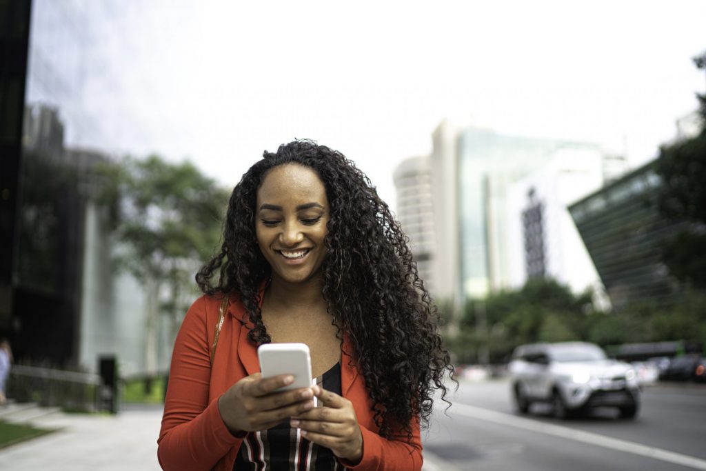 Frau, die auf Smartphone schaut als Metapher für den Artikel "Conversational Banking: der neue Trend in der Vermögensberatung"