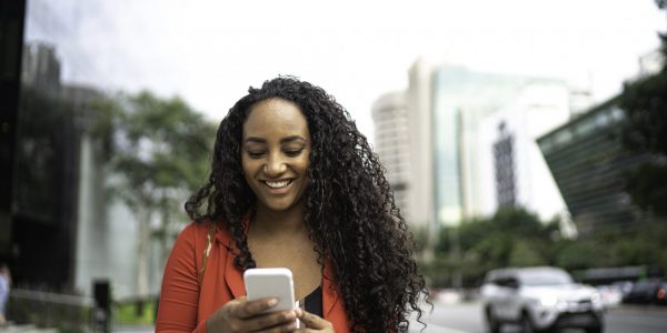 Frau, die auf Smartphone schaut als Metapher für den Artikel "Conversational Banking: der neue Trend in der Vermögensberatung"